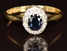 An 18ct gold ring set with an oval cut sapphire surrounded by diamonds, 2.4g, size N