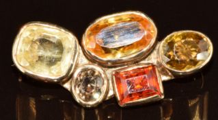 A 9ct gold brooch set with a yellow sapphire of approximately 4.7ct, garnet, helidor and zircons,