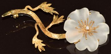 An 18ct gold brooch in the form of a flower with petals made of glass, set with a diamond to the