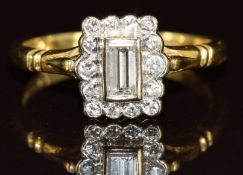 An 18ct gold ring set with a baguette cut diamond of approximately 0.15ct surrounded by round cut