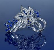 An 18ct white gold brooch set with baguette cut and round cut diamonds and round and calibre cut