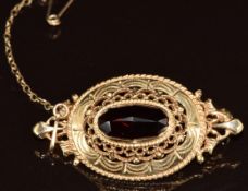 An 14k gold brooch set with a garnet in a pierced setting, 6.7g, 4cm