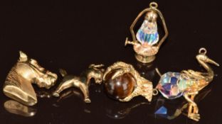 Five charms in the form of a horse's head, claw holding a tiger's eye, lamp set with a crystal bead,