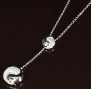 An 18ct white gold necklace in the form of Ying & Yang set with diamonds by Stubbs & Co (4cm), on