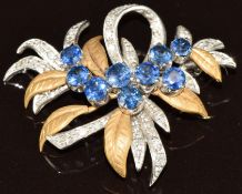 An 18ct gold bi-coloured brooch in a foliate design set with diamonds and nine round cut