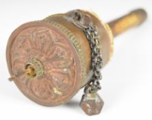 Tibetan prayer wheel with wooden handle and embossed decoration to the copper top, 22cm long.