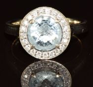 An 18k gold ring set with an aquamarine surrounded by diamonds, 5.7g, size N