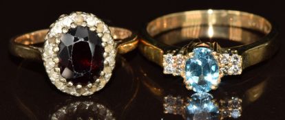 Two 9ct gold rings, one set with topaz and diamonds and one set with a garnet surrounded by