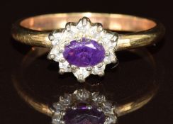 A 9ct gold ring set with an oval cut amethyst surrounded by cubic zirconia, 2.8g, size T