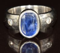 A platinum ring set with an oval cut sapphire of approximately 2.7ct and two diamonds, 8.5g, size