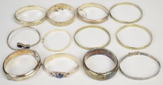 Twelve silver bangles including examples with scrolling decoration, embossed decoration, etc, 199g