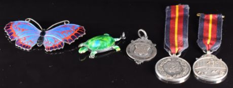 A hallmarked silver brooch in the form of a butterfly set with enamel, two silver swimming