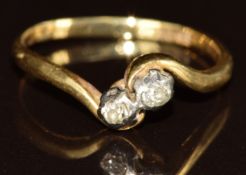 An 18ct gold ring set with two old cut diamonds in a twist setting, 2.6g, size O