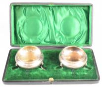 Cased pair of Edward VII hallmarked silver salts raised on three feet, Chester 1903, maker James