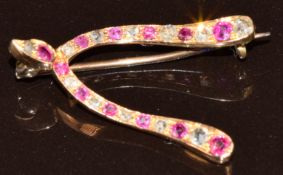 A 9ct gold wishbone brooch set with rubies and rose cut diamonds, 2.1g, 2.5 x 1.5cm
