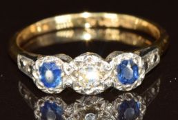 An 18ct gold ring set with a diamond and two sapphires in a platinum mount, 2.6g, size M