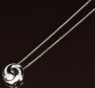 An 18ct white gold pendant in a swirl design set with diamonds (1.6cm) on 18ct white gold chain, 8.
