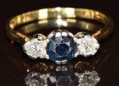 An 18ct gold ring set with a round cut sapphire of approximately 0.7ct and two old cut diamonds of