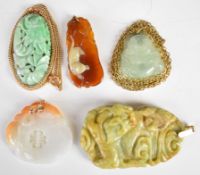 Five Chinese jade, jadeite or similar hardstone pendants two on yellow metal chains.