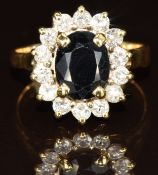 An 18k gold ring set with an oval cut sapphire of approximately 1.6ct surrounded by fourteen round