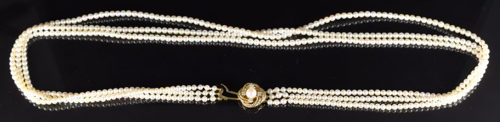 A triple strand cultured pearl necklace, the 9ct gold clasp set with a further pearl and diamonds,