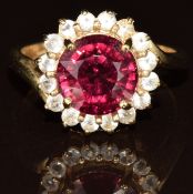 A 9ct gold ring set with a garnet of approximately 3ct surrounded by white topaz, 4.6g, size N