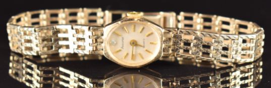 Accurist 9ct gold ladies wristwatch with gold hands and baton hour markers, silver dial and quartz