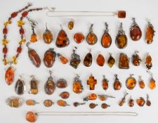 Forty silver pendants, four silver brooches and a silver ring all set with pressed amber