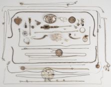 A collection of silver jewellery including two brooches, heart locket, chains, pendants, two