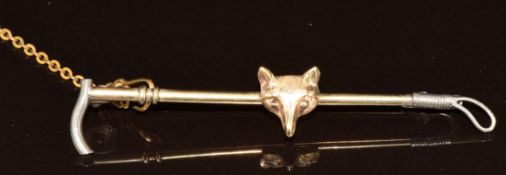 A 9ct gold brooch in the form of a fox and riding crop, 2.9g, 5.2cm