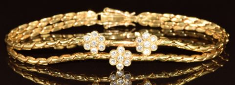 An 18ct gold bracelet set with twenty-one diamonds in three flower clusters, each approximately 0.