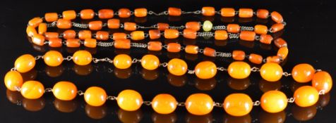 Two amber necklaces, one made up of 21 graduated oval beads, the largest 18x14mm and the  smallest