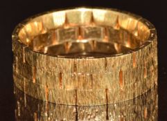 An 18ct gold ring made up of textured rectangular panels, with hinged movement, 8g, size O