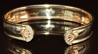 A 9ct gold bangle set with diamonds in shell setting, 9.3g