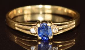 An 18ct gold ring set with an oval cut sapphire and two diamonds, 1.6g, size I