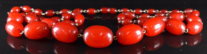 A cherry amber necklace made up of 45 graduated oval beads, the largest 28x22mm and the smallest