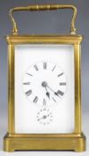 19th or early 20th century gilt cased carriage clock with bevelled glass panels, the white enamel