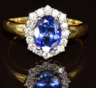An 18ct gold ring set with an oval cut tanzanite of approximately 1.2ct surrounded by diamonds, 3.