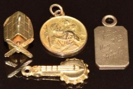 A 9ct gold St Christopher (1.4g), and three 9ct gold charms, one in the form of a windmill (0.9g),