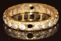 An 18ct gold eternity band set with spinel (two missing), 3g, size M