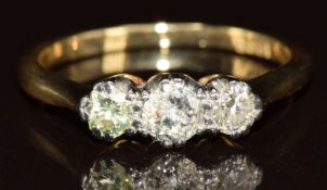 An 18ct gold ring set with three diamonds, the centre diamond approximately 0.25ct, 2.6g, size L