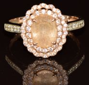 A 14k rose gold ring set with an oval cut morganite of approximately 1.4ct surrounded by pink