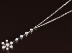 An 18ct white gold pendant set with seven round cut diamonds in a snowflake setting (3.6cm), on 18ct