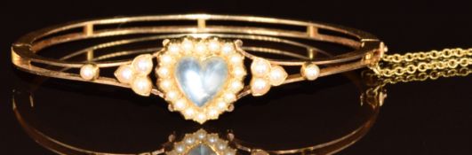 Edwardian 9ct gold bangle set with a heart cut moonstone surrounded by split pearls, 11.3g, 5.4 x