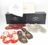 Three pairs of Prada sandals including red leather, red flower and bronze leather with stone