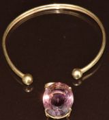 A 9ct gold torque bangle (2.8g) and 9ct gold pendant set with an oval cut amethyst (5.8g)