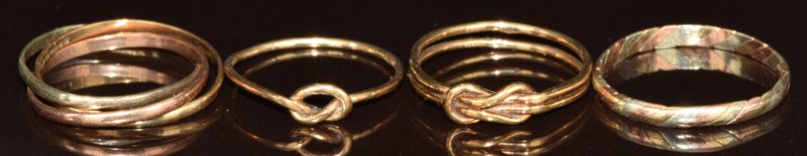Four 9ct gold rings including two with knot design, one Russian style wedding band and a tri-