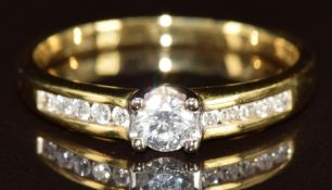 An 18k gold ring set with a diamond of approximately 0.25ct and further diamonds to the shoulders,