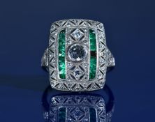 Art Deco platinum ring set with seventeen calibre cut emeralds, an old cut diamond of