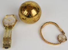 A mid-20th century brass Pygmalion spherical globe powder compact, Avia watch and 9ct gold cased